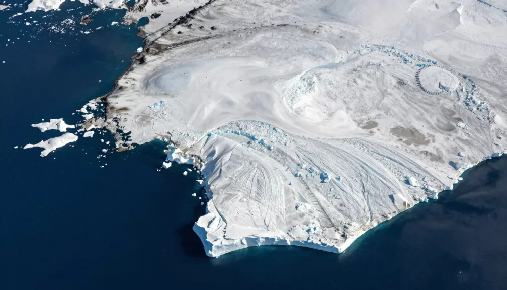 Aerial view of Greenland's vast ice sheet and rugged coastline, showing why it's the world's largest island