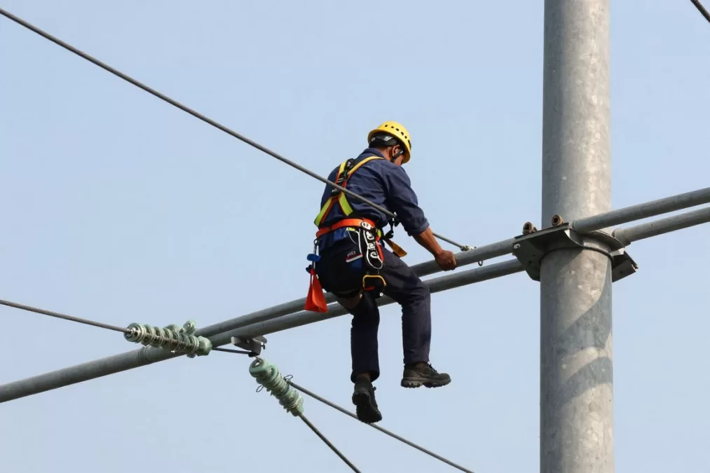 Power line installer working on electrical transmission lines