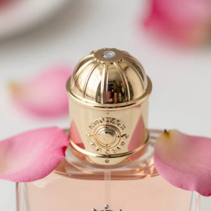 Close-up of Amouage Gold Woman perfume with rose petals