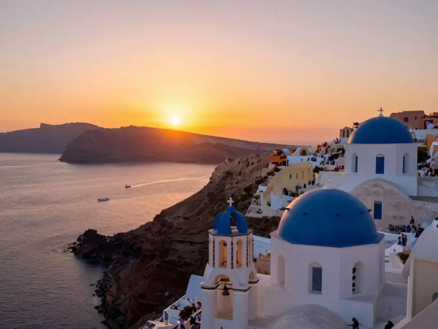 Sunset view from Oia Santorini with crowds gathering at castle ruins