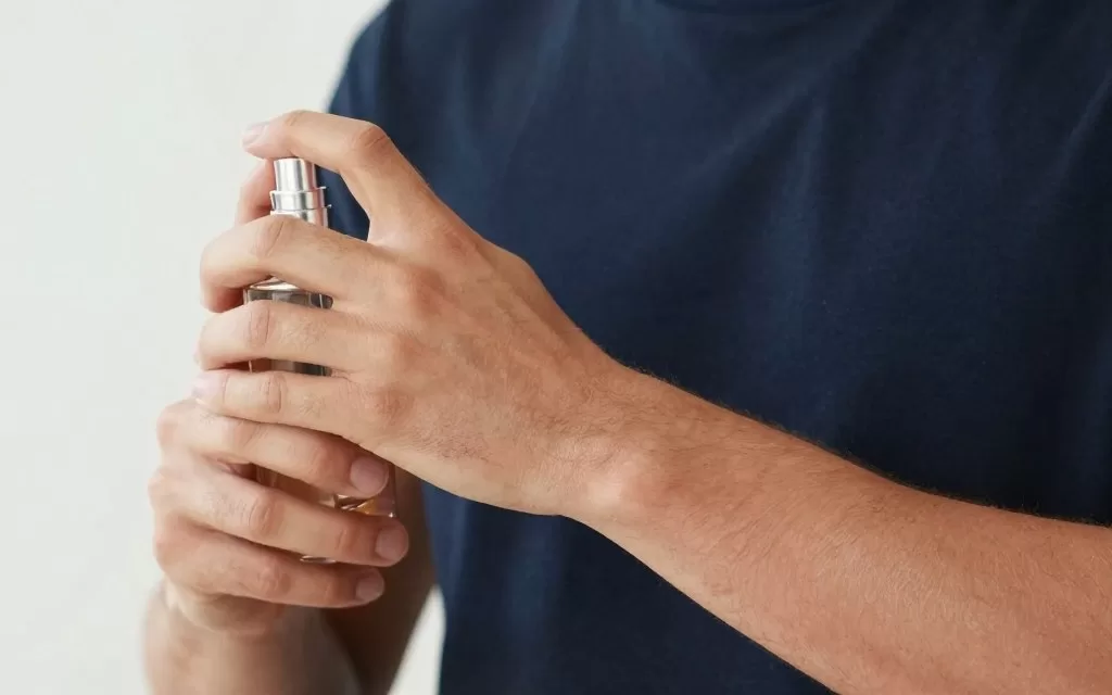 Man applying cologne to pulse points properly