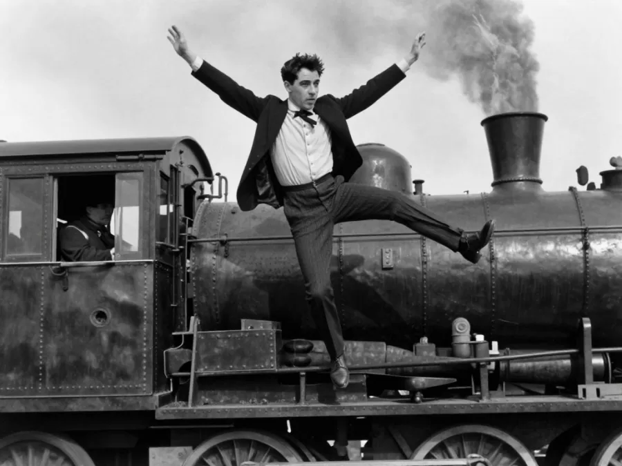 Buster Keaton performing dangerous stunt on moving train