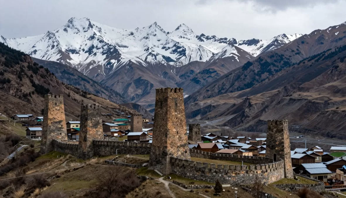 Svaneti medieval towers with snow-capped Caucasus mountains