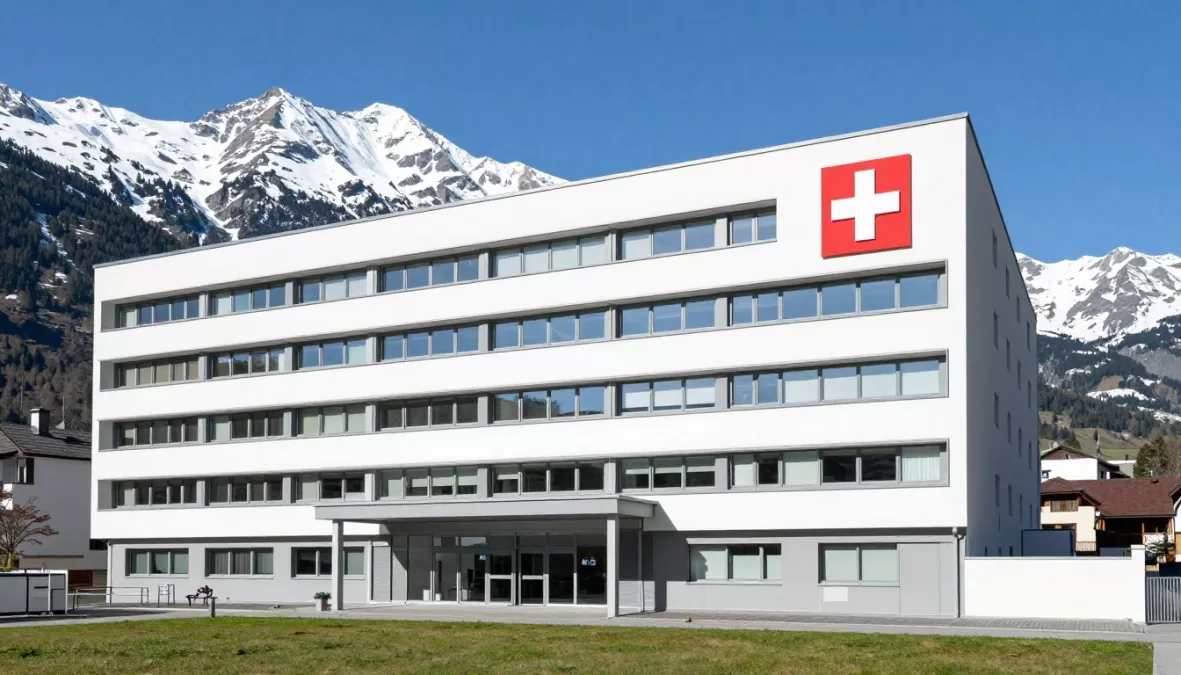 Swiss hospital with Alpine mountains in background representing quality healthcare