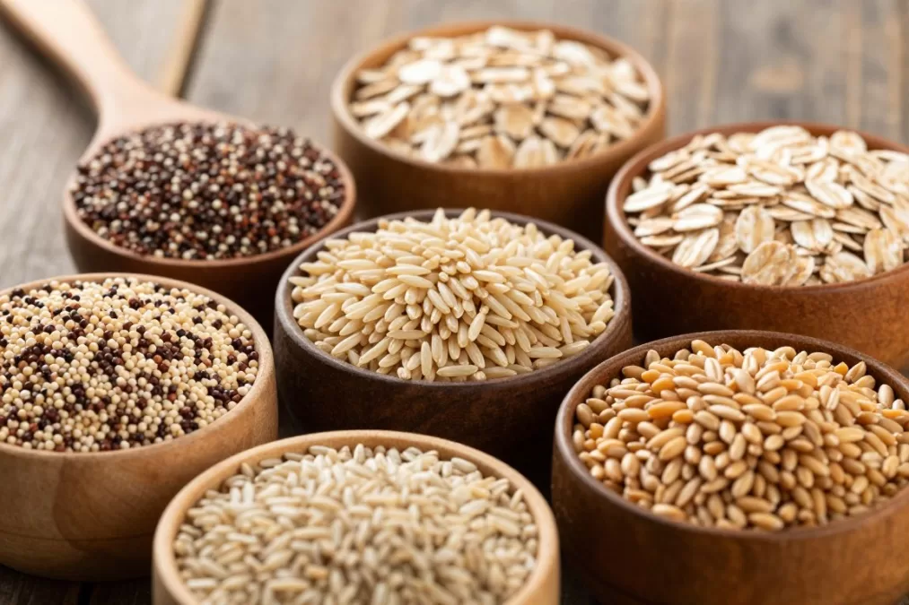 whole grains including quinoa, brown rice, oats, and whole wheat arranged to show texture and variety
