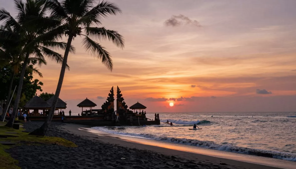Bali beach with traditional temple and tropical palm trees at sunset