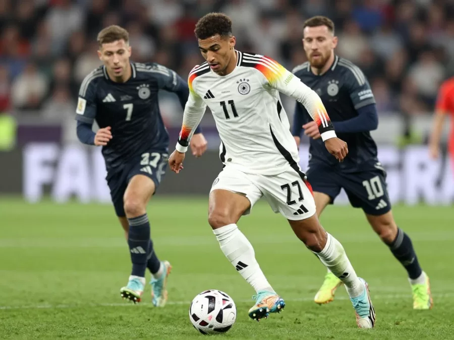 Jamal Musiala dribbling past defenders in Germany white jersey