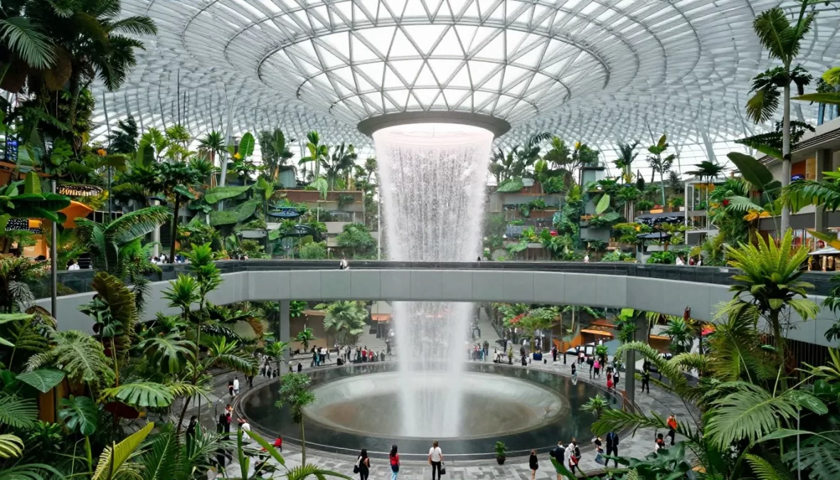 Singapore Changi Airport interior featuring the iconic indoor waterfall and lush tropical garden with modern architecture