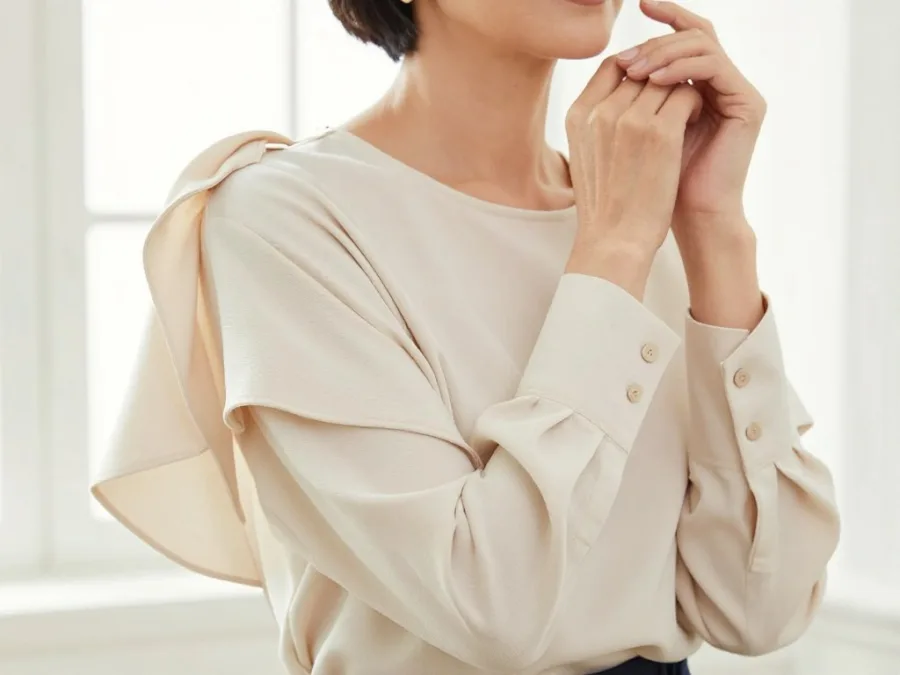 Woman over 50 wearing blouse with statement sleeves