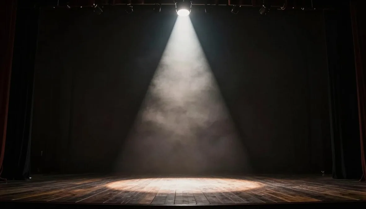 A stage spotlight illuminating an empty stage platform with smoke