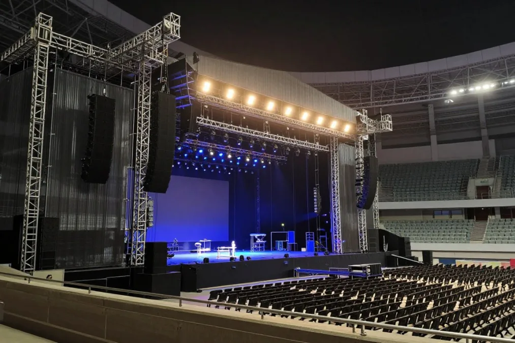 Concert stage lighting rig and audio speakers in an arena Concert stage lighting rig and audio speakers in an arena