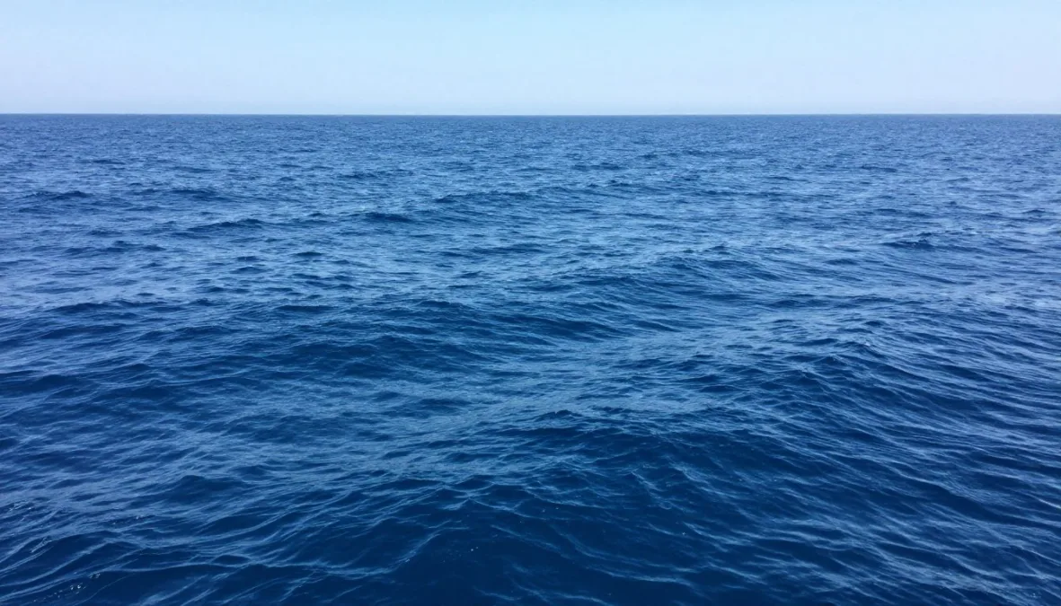 Open ocean water surface with small waves beneath daylight Open ocean water surface with small waves beneath daylight
